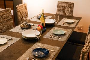 a table with plates and glasses and a bottle of wine at MIRATIO Saphir in Onna