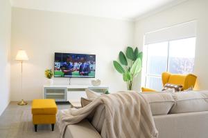 a living room with a couch and a tv at StayAU 5BRM Coastal Retreat for Families Baldivis in Baldivis