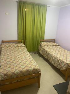 2 camas en una habitación con cortina verde en paseo San Carlos, en Coquimbo 6 fotos más