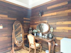 a dressing table with two chairs and a mirror at Grand Amazon Hotel in Lampang +26 photos