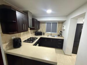 a kitchen with a stove and a sink in it at Apartamento de Lujo in Floridablanca