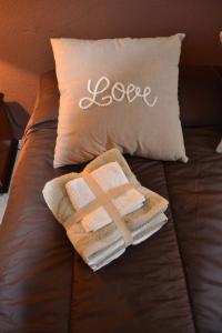 a bed with towels and a pillow with the word love at Apartamento Santa Eulalia in Merida