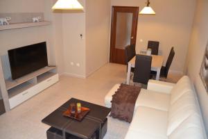 a living room with a white couch and a table at Apartamento Santa Eulalia in Merida