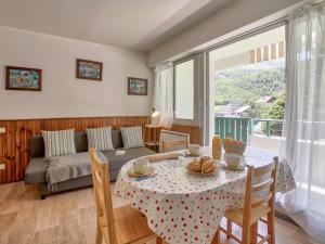 a living room with a table and a couch at Appartement cosy pour 4 à Gourette, balcon sud-ouest et services optionnels - FR-1-400-134 in Eaux-Bonnes