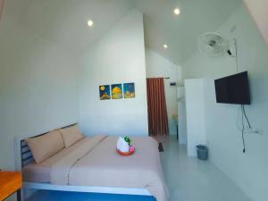 a living room with a couch and a television at ไวท์เฮาส์ ภูชี้ฟ้า in Ban Tin Pet