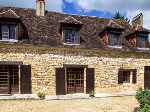 an old stone house with windows and a roof at Maison campagnarde avec piscine et cheminée, Périgord Noir - FR-1-616-395 in Thenon