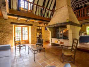 a living room with a stone fireplace and chairs at Maison campagnarde avec piscine et cheminée, Périgord Noir - FR-1-616-395 in Thenon