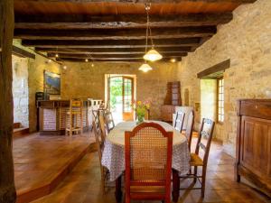 a kitchen and dining room with a table and chairs at Maison campagnarde avec piscine et cheminée, Périgord Noir - FR-1-616-395 in Thenon