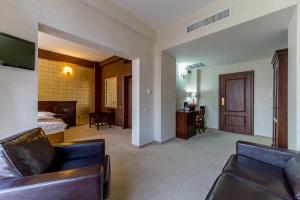 a hotel room with a couch and a bed at Hotel Rexton in Craiova