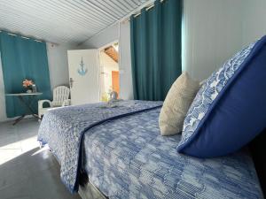 ein Schlafzimmer mit einem Bett mit einer blauen Bettdecke in der Unterkunft Trillizas Del Mar Beach Sunset View - Casa Cielo in Tubod