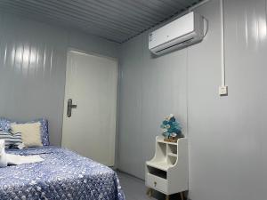 ein Schlafzimmer mit einem Bett und einer an der Wand montierten Klimaanlage in der Unterkunft Trillizas Del Mar Beach Sunset View - Casa Cielo in Tubod