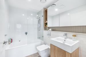 een badkamer met een wastafel, een toilet en een douche bij Your Luxury Weekend Getaway in Wentworth Point in Sydney