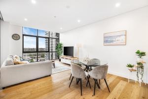 een woonkamer met een tafel en een bank bij Your Luxury Weekend Getaway in Wentworth Point in Sydney