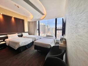 a hotel room with two beds and a large window at Epoch Hotel in Hong Kong
