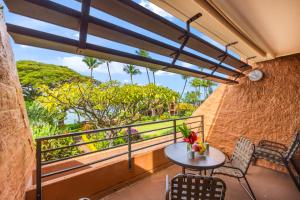 a balcony with a table and chairs and a window at Kuleana Club #510 - Ocean View -1 bedroom & 1 bathroom - 2nd Floor in Kahana