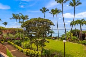 a view of a park with palm trees and the ocean at Kuleana Club #510 - Ocean View -1 bedroom & 1 bathroom - 2nd Floor in Kahana