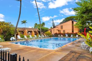 a large swimming pool with chairs and a building at Kuleana Club #510 - Ocean View -1 bedroom & 1 bathroom - 2nd Floor in Kahana