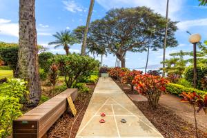 a garden with a ping pong table and benches at Kuleana Club #510 - Ocean View -1 bedroom & 1 bathroom - 2nd Floor in Kahana
