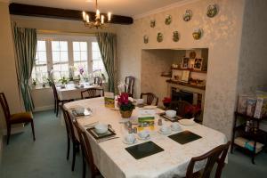 a dining room with a long table and chairs at Weir Mill Farm in Cullompton