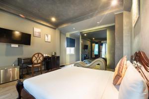 胡志明市Happy Homes Ben Thanh Central的一间卧室配有一张床和一张书桌,另一间卧室配有一张桌子。