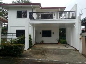 a white house with a balcony on top of it at casa lilia in Tagaytay