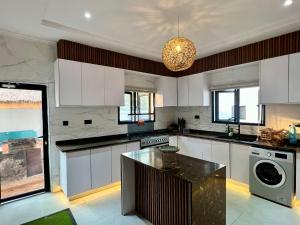 a kitchen with white cabinets and a black counter top at Masque Lagos in Lagos