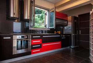 a kitchen with red cabinets and a window at Villa Maria & George in Nydri