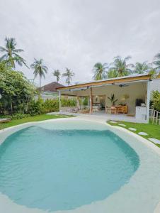 a large swimming pool in front of a house at Gili Boho Villas - Aesthetic Private Pool Villas in Gili Trawangan