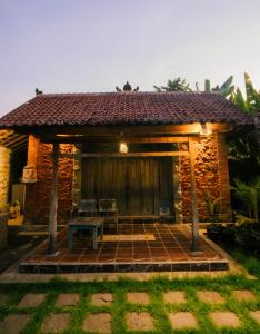 a small house with a bench in front of it at Kapten Nyoman House in Saba