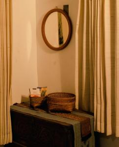 a mirror and two baskets on a dresser in a room at Kapten Nyoman House in Saba