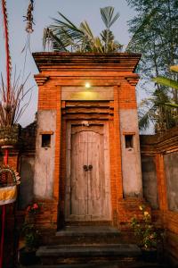 a small brick building with a wooden door at Kapten Nyoman House in Saba