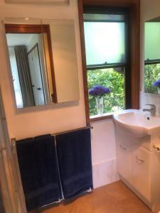 a bathroom with a sink and a mirror at Cosy Golf Course Retreat in Tamborine Mountain with Wifi & Aircon in Mount Tamborine