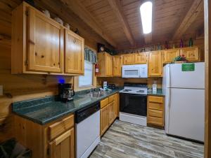 a kitchen with wooden cabinets and a white refrigerator at ER206 - Mountain Rendezvous Great location - Close to town! cabin in Pigeon Forge