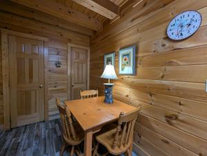 a dining room with a table and a clock on the wall at ER206 - Mountain Rendezvous Great location - Close to town! cabin in Pigeon Forge