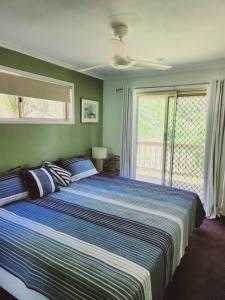 a large bed in a bedroom with a window at Bushland View Retreat in Ocean Shores