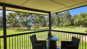 een veranda met stoelen en uitzicht op een golfbaan bij Mary MacKillop Spirituality Centre Central Coast in Kincumber South +7 foto's