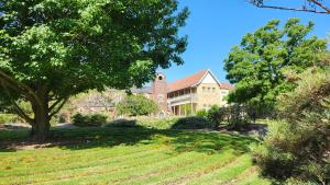 een groot huis met een boom en een grasveld bij Mary MacKillop Spirituality Centre Central Coast in Kincumber South