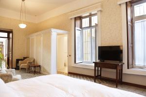 a bedroom with a bed and a flat screen tv at Casa Falguera en el Centro de Guanajuato 10p in Guanajuato +32 photos