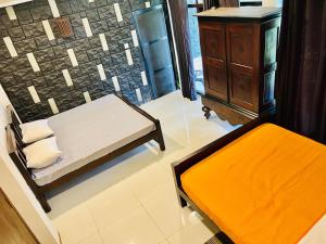 a bed and a bench in a room with a stone wall at Pale's Villa in Galle