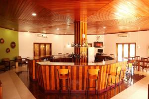 a kitchen with a bar with stools in it at Hotel Praia in São Tomé +23 photos