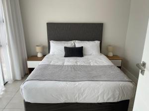 a bedroom with a large bed with a black headboard at Ballito Hills unit 350 in Ballito +28 photos