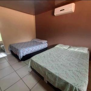 ein Zimmer mit zwei Betten und einer Klimaanlage in der Unterkunft vivencias in Itaquatiara