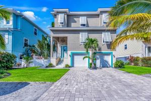 een groot huis met een oprit en palmbomen bij Paradise on Pine in Anna Maria