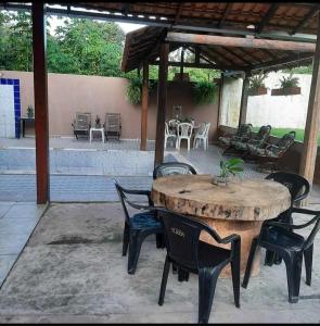 einen Holztisch und Stühle auf einer Terrasse in der Unterkunft vivencias in Itaquatiara