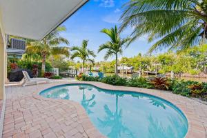 een zwembad in een tuin met palmbomen bij Paradise on Pine in Anna Maria