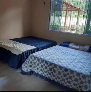 ein Zimmer mit zwei Betten und einem Fenster in der Unterkunft vivencias in Itaquatiara