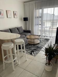 a living room with a couch and a table and stools at Ballito Hills unit 350 in Ballito