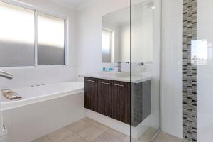 Un baño blanco con bañera y lavabo. en Windward Marina Retreat, en Geographe 22 fotos más