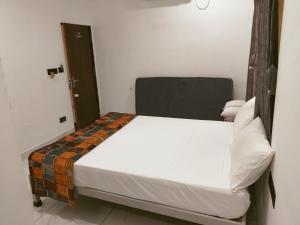 a bed in a small room with a white bed sidx sidx sidx at Gurukrupa Yatri Niwas in Garudeshwar