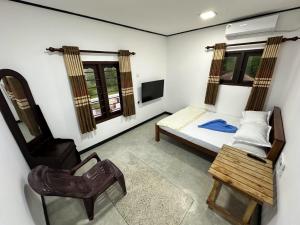 una piccola stanza con un letto e una sedia di Coco Inn Polhena a Matara